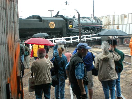 people in back door of roundhouse looking through rain at 700 on the turntable