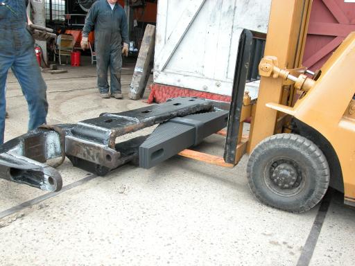 forklift putting new spring bundle into side frame